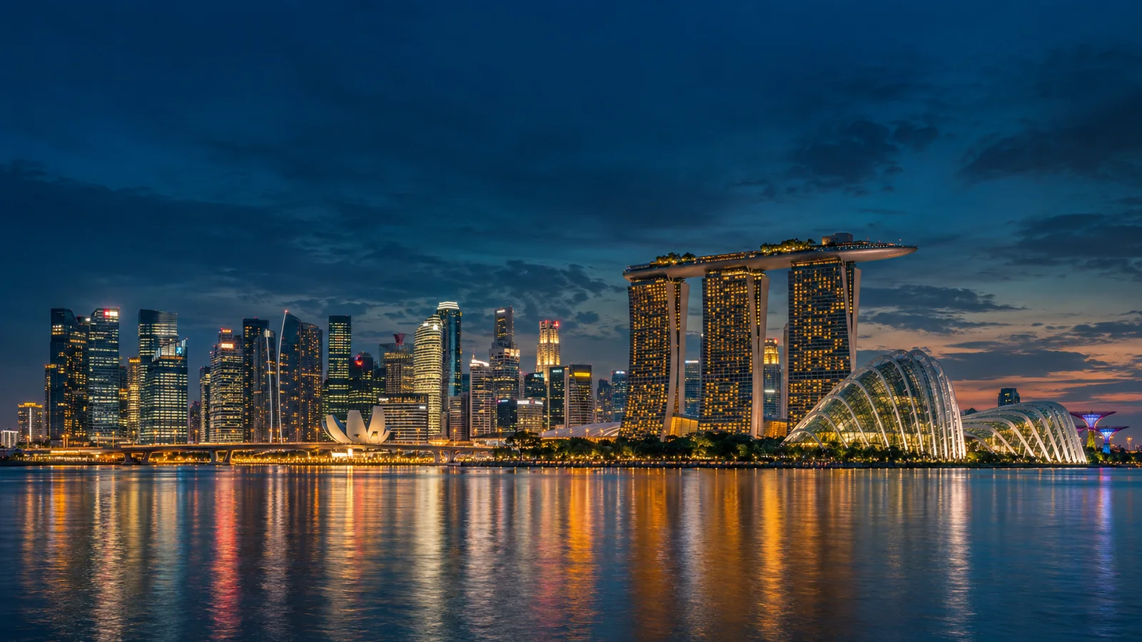 AI-generated view of Singapore’s Marina Bay skyline at blue hour, with illuminated landmarks reflected in the water
